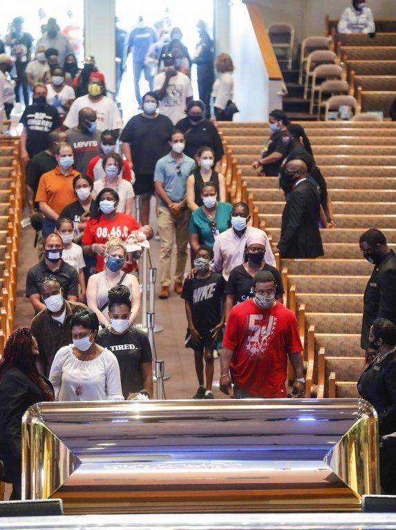 People-file-past-coffin.