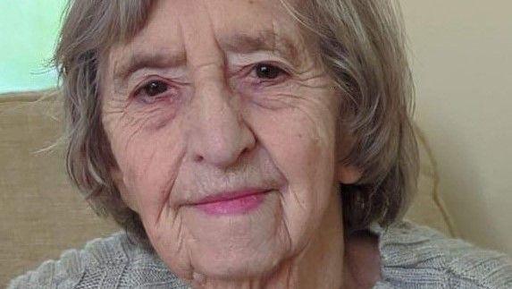 Emma Finch faces the camera, half-smiling. She has neck-length light-brown/grey hair and wears a light grey jumper.