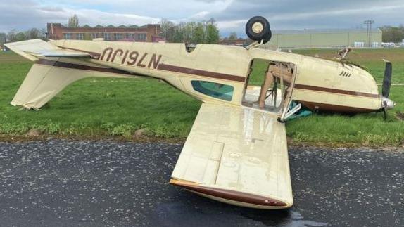 A plane upside down on a runway.