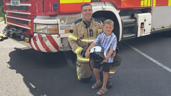 Firefighter Tom Robjohns and his son Alfie in front of a fire truck