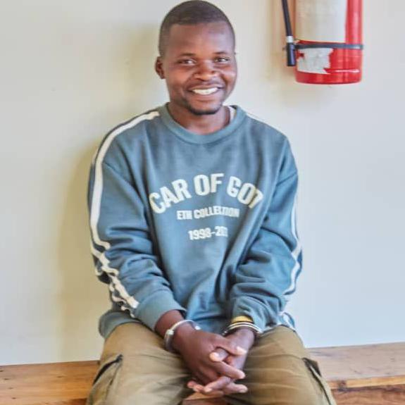 Shadrack Chaula sitting in a police station with handcuffs