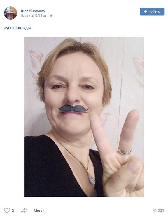 Irina Kuptsova making a V sign, wearing a fake moustache