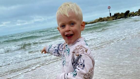 Oscar at the seaside pointing out towards the sea.