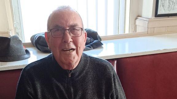 Dave, 82, has dark hair and glasses.