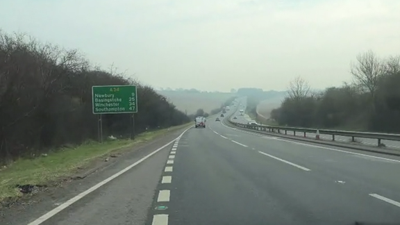 A shot taken through a car's windscreen as the driver pulls out onto the A34 from a slip road heading south towards Newbury    