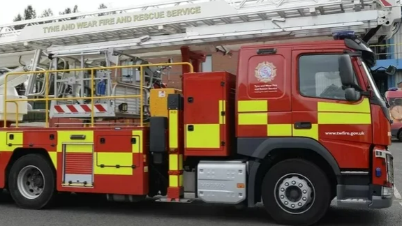 A red fire engine with yellow checks and Tyne and Wear Fire and Rescue Service branding