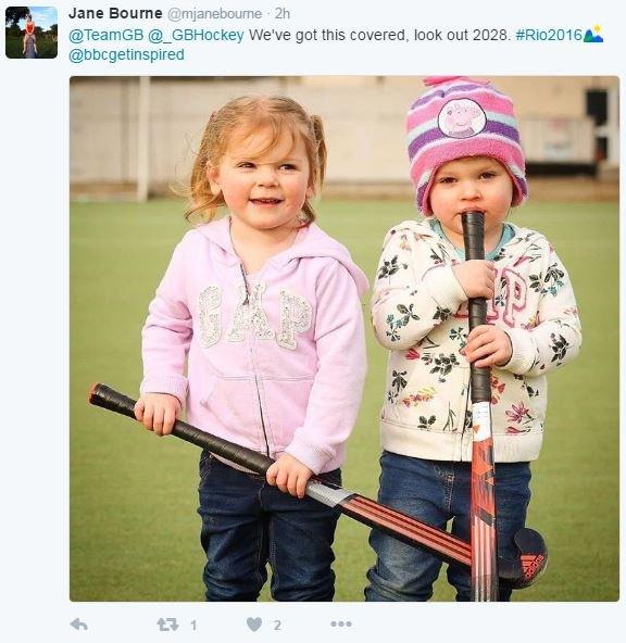 Two young girls holding hockey sticks