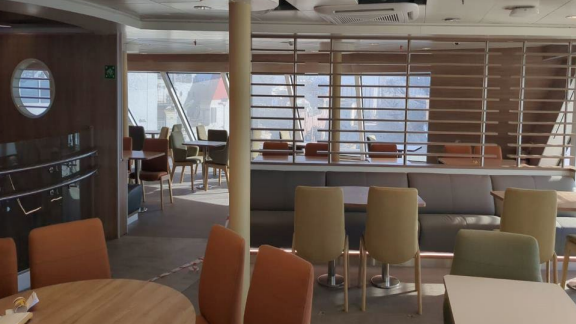 chairs and tables in an interior passenger space on the ship