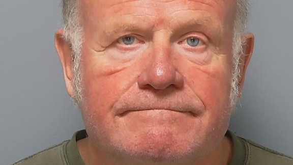 In a police custody photo, Martin Suter is bald, with light grey hair on the side and blue eyes.