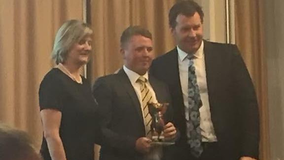 Jack Yule receives a trophy from Sir Nick Faldo