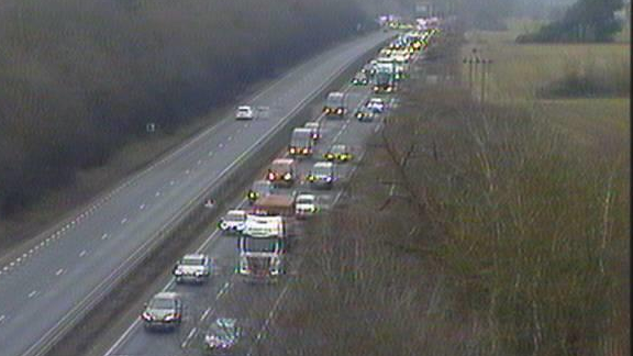 Traffic queues on the A14 carriageway. Vehicles can be seen backed up closely together as they slowly move along the road.