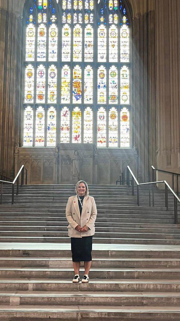 Amanda Martin standing on steps with stained glass window in the background