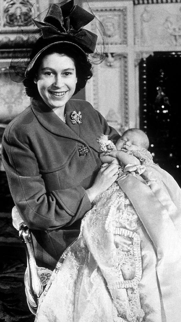 Queen Elizabeth II holds her son Prince Charles Philip Arthur George at his Christening in 1948.