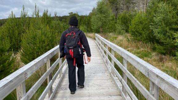 Neach-coise air slighe fiodha ann an Coille Coimhearsnachd Ath Linne