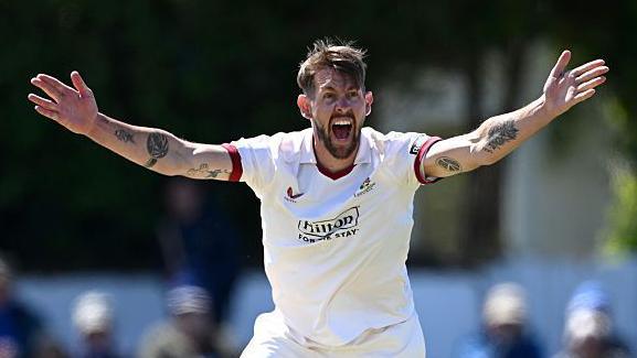 Playing in a Championship game, Tom Bailey has both arms outstretched appealing for a wicket towards the umpire