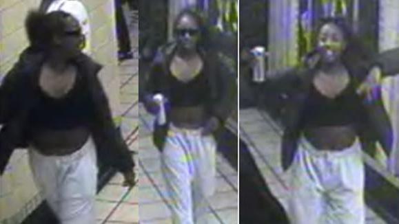 A blurred CCTV image of a woman in a London underground station who is wearing light coloured jogging bottoms with a black top and a dark coloured jacket.