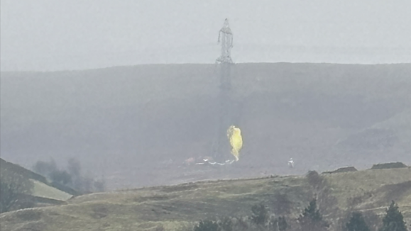 An image being shared on social media later showed what appeared to be a parachute caught on a nearby pylon, showing a yellow material in misty conditions