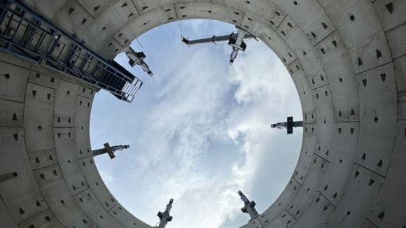 View from inside a large sewer pipe, looking up to the sky.