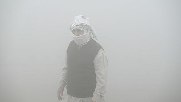 Commuters step out in a foggy winter morning amid rising air pollution, on November 19, 2024 in Greater Noida, India