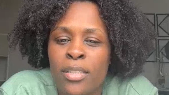 Jacinta Bathalda has a light green top and black permed hair.