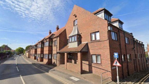 Side view of the development, which is comprised of lightly coloured brown brick work and dark brown windows