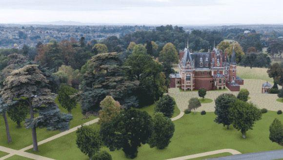 A large grassed area, with trees dotted around the landscape, with a large red chateau-style building in the background. 
