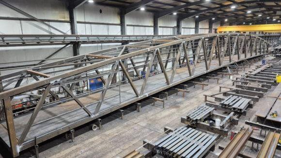 A grey steel bridge in a warehouse. 
