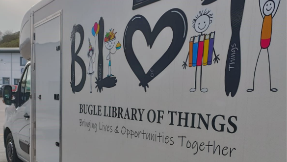 The left side of a white van with the words including Bugle Library of Things and some graphics of children.