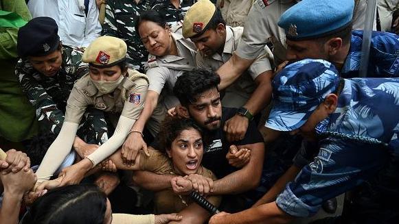 Indian wrestlers Vinesh Phogat (C) with others are detained by the police while attempting to march to India's new parliament, just as it was being inaugurated by Prime Minister Narendra Modi, during a protest against Brij Bhushan Singh, the wrestling federation chief, over allegations of sexual harassment and intimidation, in New Delhi on May 28, 2023.