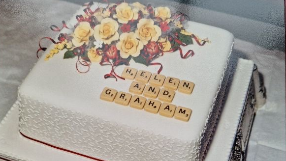 Helen and Graham scrabble theme wedding cake which says 'Helen and Graham' in scrabble tiles 