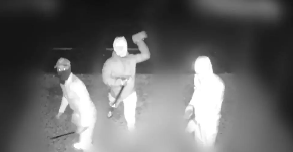 CCTV image shows three people, with their faces covered, carrying weapons and looking into the camera. One person had his arm above his head about to throw a brick. 