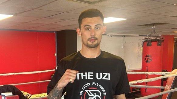 Man stands in boxing gym 