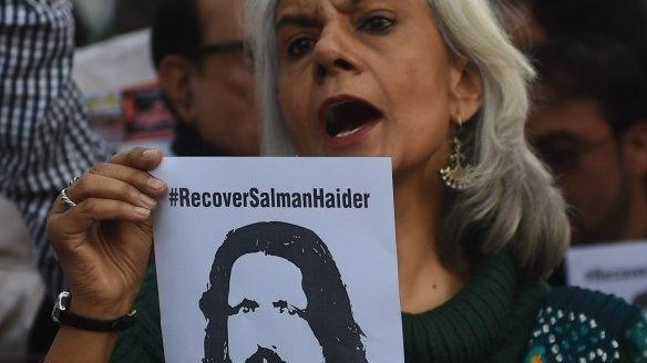 Pakistani human rights activists hold images of bloggers who have gone missing during a protest in Peshawar on January 10, 2017.