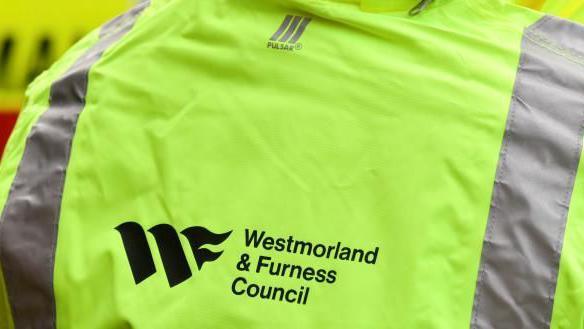 A worker wearing a Westmorland and Furness Council hi-vis jacket.