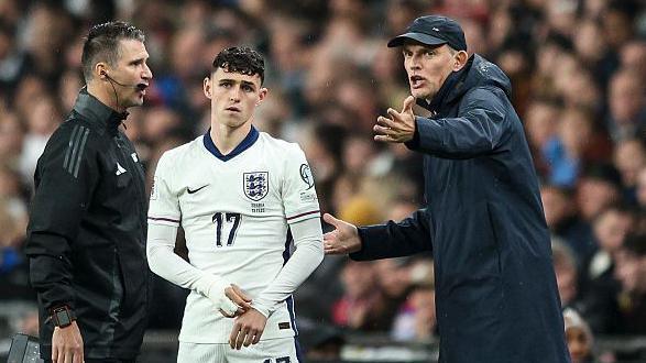 Thomas Tuchel gesticulates while standing next to Phil Foden