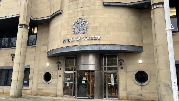 Bradford Crown Court, with a revolving door and lettering reading "The Law Courts" above the door.