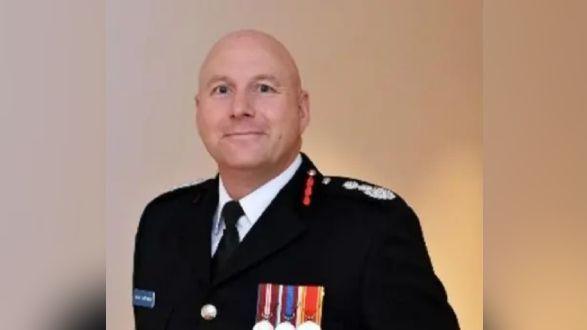 Simon Hardiman in his black fire service uniform with medals on the jacket