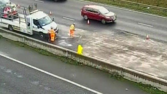 National Highways staff clear the spillage on the M62