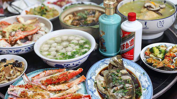 A table laid with a lavish array of Chinese food, including fish, vegetables and soups