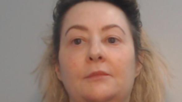 Police custody mugshot of Samantha Wall, who has mid-length dark hair at the top and bleached blonde hair dropping down on to her shoulders.