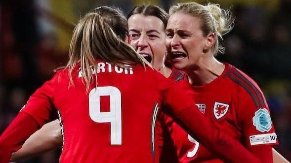 Kayleigh Barton of Wales (9) celebrates scoring the equalising penalty with teammates