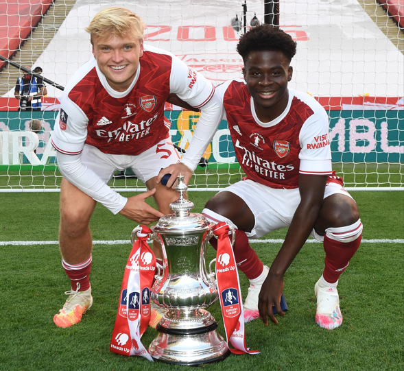 Matt Smith (left) and Bukayo Saka pose with the FA Cup trophy after Arsenal beat Chelsea in the final at Wembley in 2020