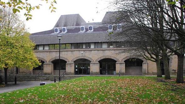 Lancaster Court House - with green gardens in front of it and autumn leaves on the floor