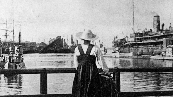 A black and white image of a girl looking onto a busy harbour 