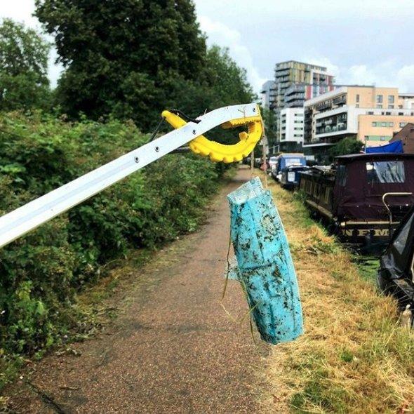 A litter picker holding a face mask