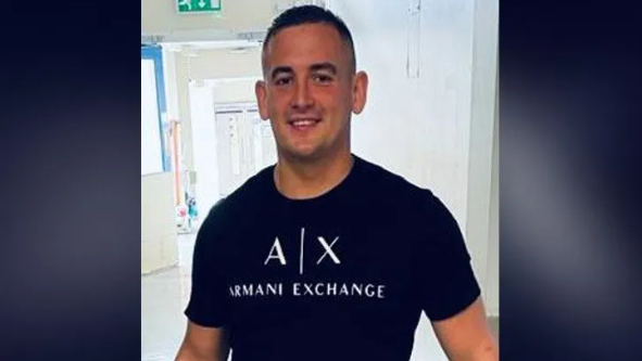 Thomas Boom in a black tshirt with AX Armani Exchange in white lettering across chest