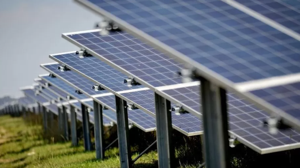 A row of solar panels in a grass field