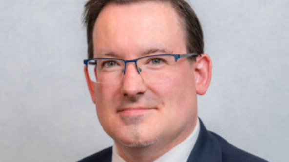 Headshot of politician Lawrie Hooper. He has glasses and is smiling.