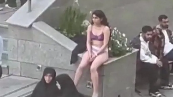 Screengrab of a video showing an Iranian woman sitting in her underwear at the Science and Research Branch of Islamic Azad University in Tehran, Iran. There are groups of other people