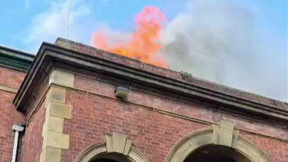Flames from the top of a red brick building